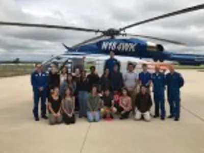 People in front of a helicopter