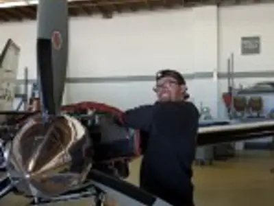 Person next to airplane propeller