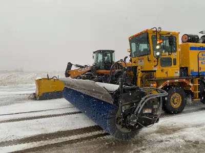 Snow sweeper on airport runway during storm
