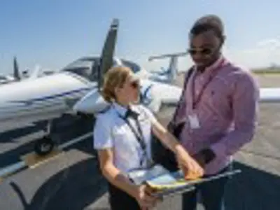 Two people discussing in front of plane